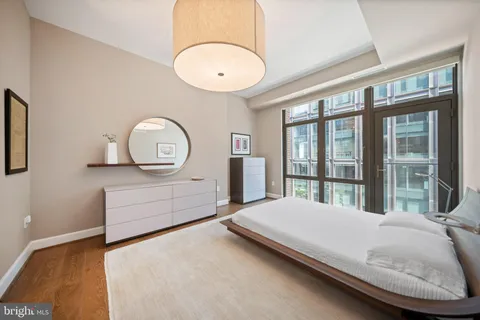 a bedroom with a bed mirror and a window