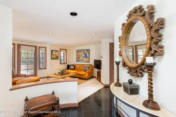 a living room with furniture a flat screen tv and a floor to ceiling window