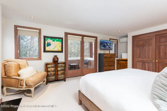 a bedroom with a bed mirror and a window