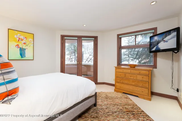 a spacious bedroom with a bed a couch and a window