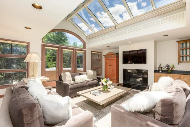a living room with furniture fireplace and a large window