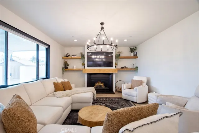 a living room with furniture a fireplace and a chandelier