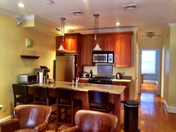 a kitchen with stainless steel appliances granite countertop a sink a stove and a refrigerator