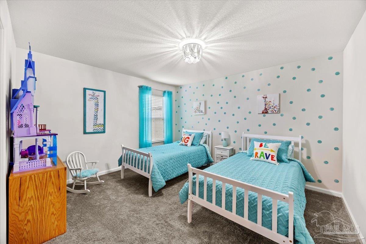 3473 Quail Drive Pace, FL 32571 - Photo 24 of 38 a bedroom with two beds and a chandelier
