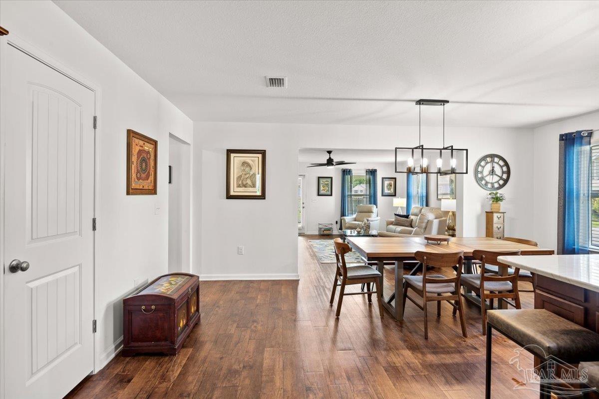 3473 Quail Drive Pace, FL 32571 - Photo 8 of 38 a view of a dining room with furniture and wooden floor