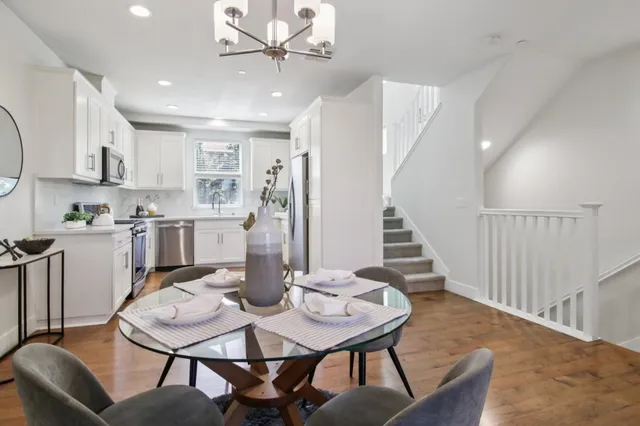 a kitchen with white cabinets stainless steel appliances and wooden floor