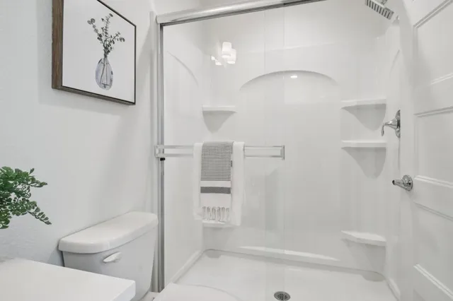 a bathroom with a toilet and a shower