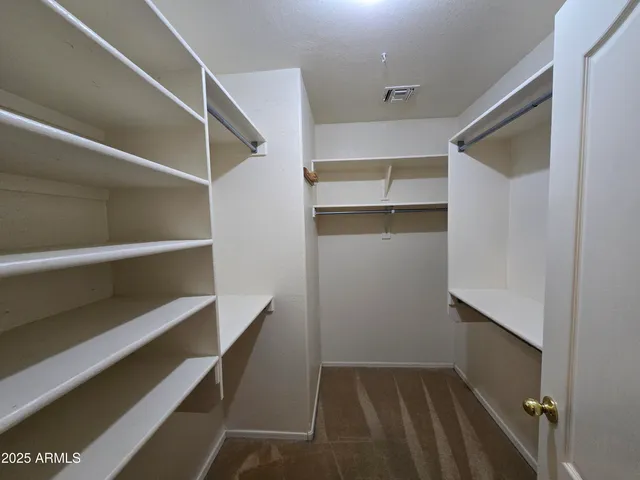 a view of walk in closet with empty racks