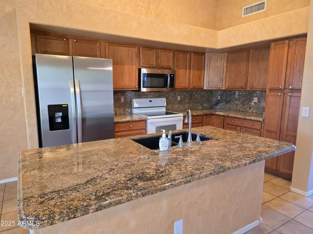 a kitchen with a sink refrigerator and microwave
