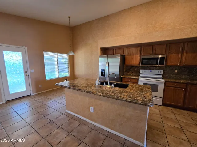 a kitchen with stainless steel appliances granite countertop a sink stove and cabinets