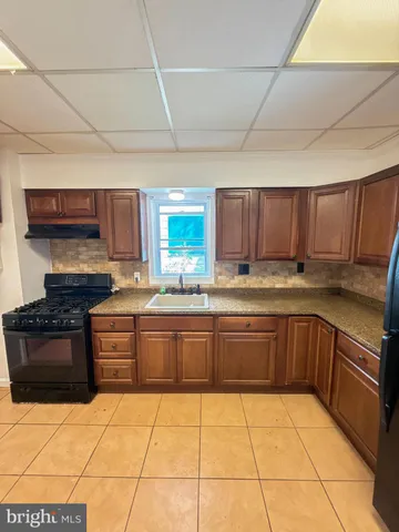 a large kitchen with granite countertop a stove a sink dishwasher and a refrigerator