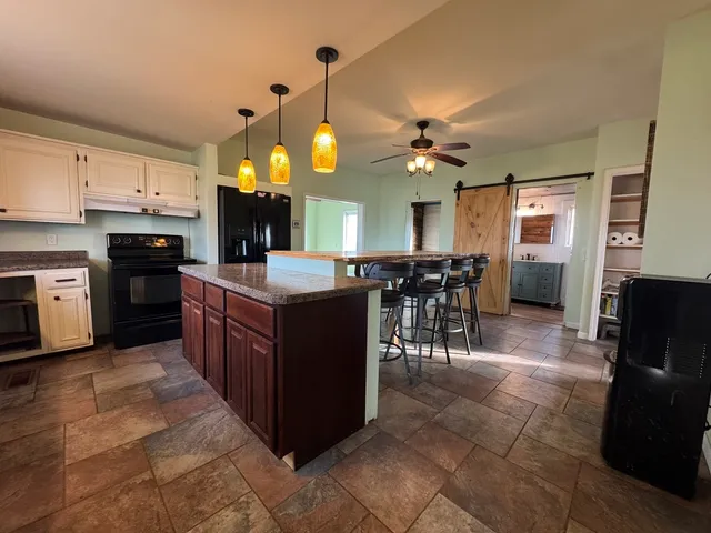 a kitchen with stainless steel appliances granite countertop a stove a sink a dining table and chairs