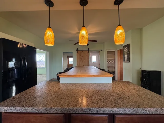 a view of a room with chandelier fan and wooden floor