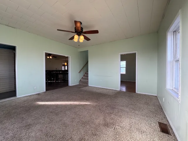 a view of empty room with kitchen