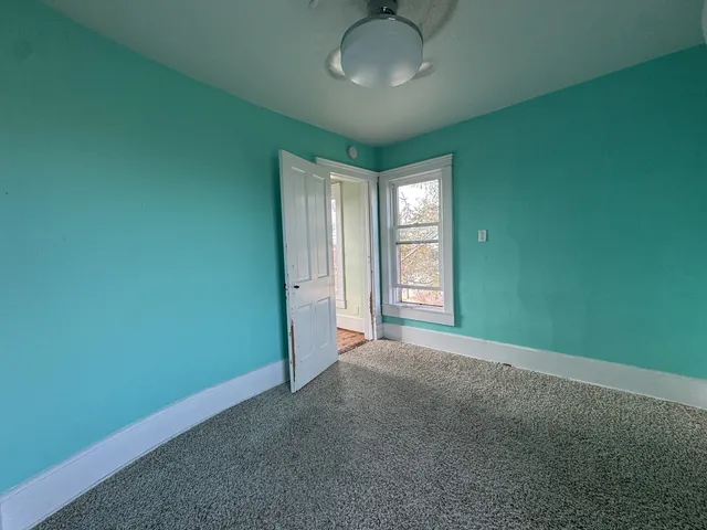 an empty room with closet and windows