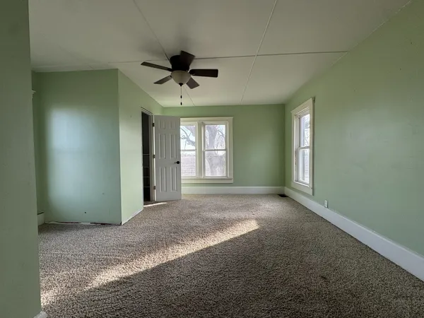 a view of a livingroom with a ceiling fan and window