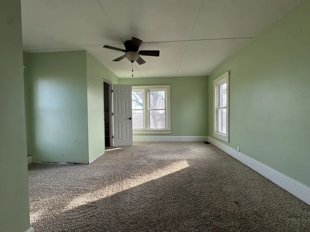 a view of a livingroom with a ceiling fan and window