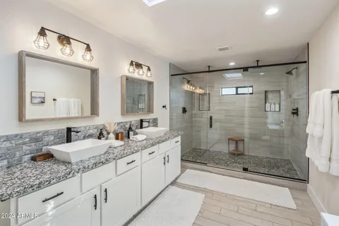a bathroom with double sink and a mirror