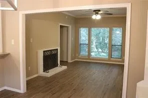 an empty room with windows and fireplace