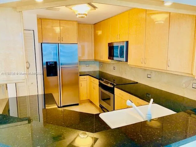 a kitchen with stainless steel appliances kitchen island a tub sink and cabinets