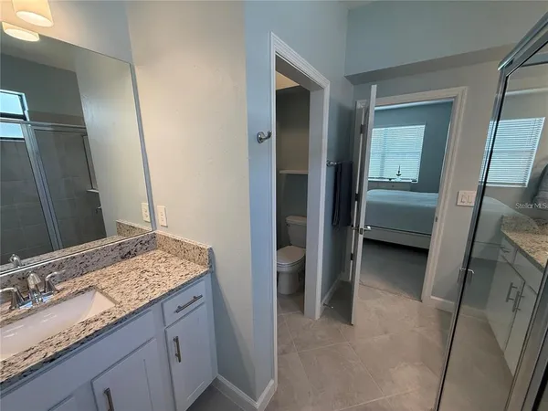 a bathroom with a granite countertop sink mirror and double