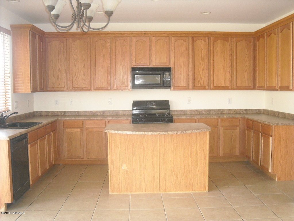 14142 West Boca Raton Road Surprise, AZ 85379 - Photo 6 of 11 a kitchen with cabinets a sink and a stove
