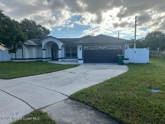 a front view of a house with a garden and yard