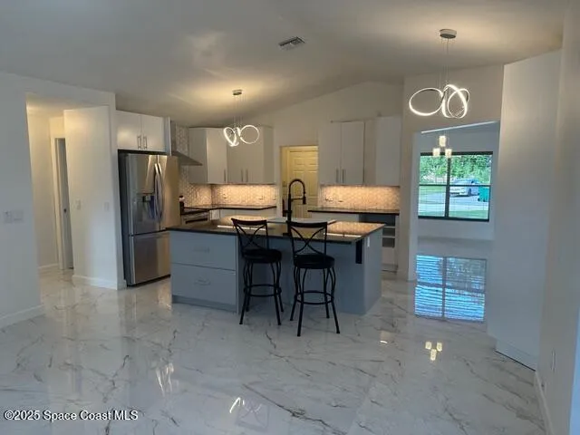 a kitchen with cabinets and refrigerator