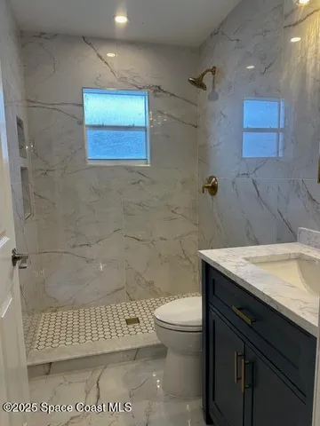 a bathroom with a sink a toilet and mirror