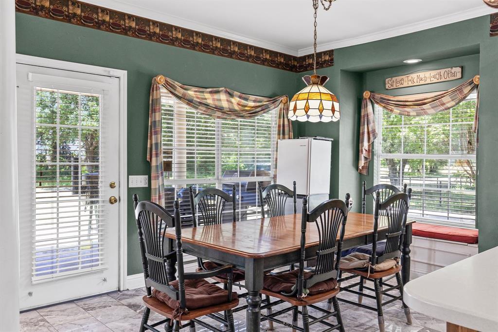 7581 Highway 24 Commerce, TX 75428 - Photo 16 of 40 a dining room with furniture a chandelier and wooden floor