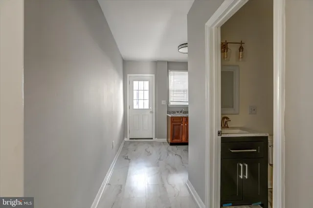 a view of hallway with a sink and a window