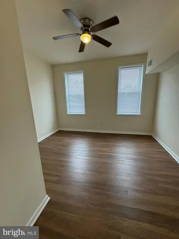 a view of room with wooden floor and windows