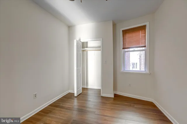 an empty room with wooden floor and a window