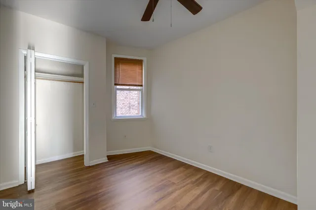 an empty room with wooden floor and window