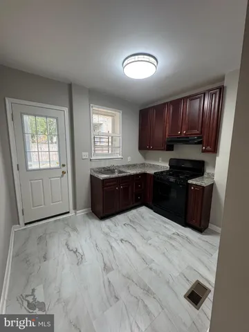 a large kitchen with granite countertop wooden cabinets and a sink
