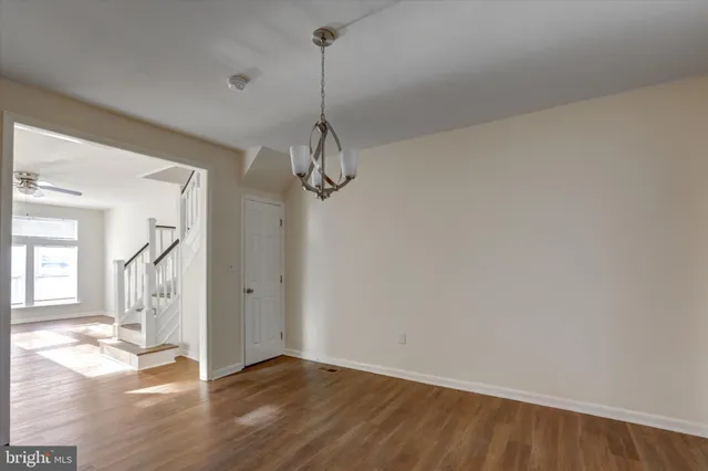 a view of empty room with wooden floor and window