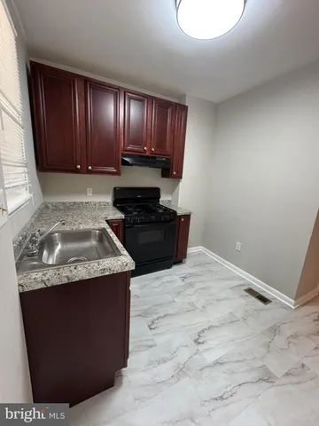 a kitchen with granite countertop cabinets sink and stove