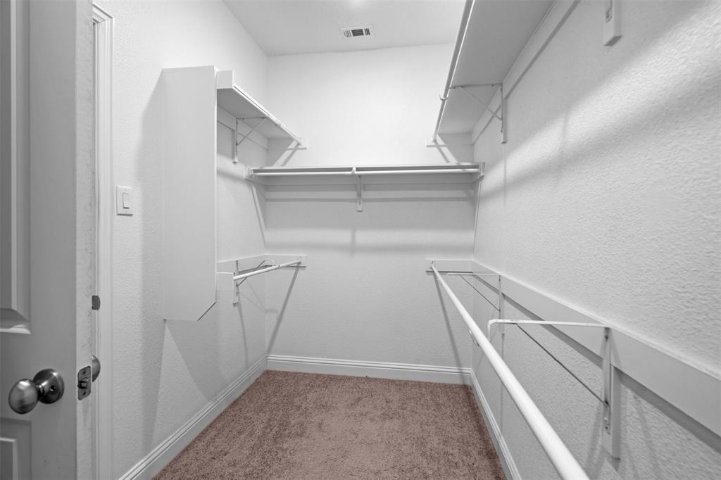 119 Happy Lane Red Oak, TX 75154 - Photo 22 of 37 Walk-in closet featuring built-in shelving, hanging rods, and carpet flooring