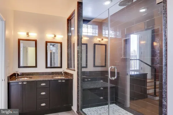 a bathroom with a mirror a sink and glass door