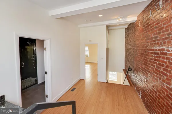 a view of a hallway with wooden floor and staircase