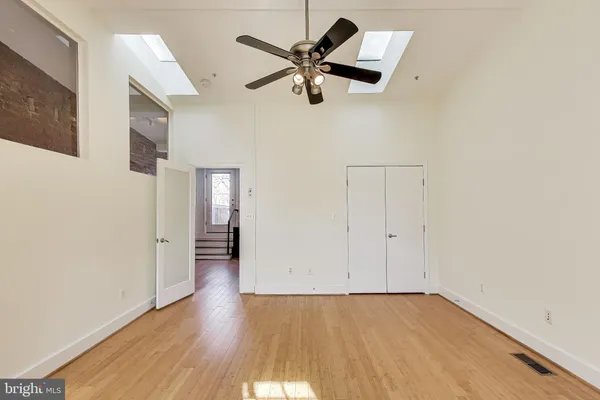 a view of an empty room with wooden floor