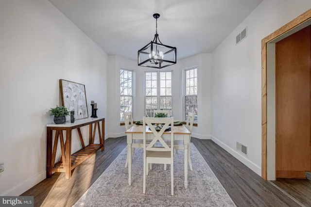 a view of a a dining room with furniture window and wooden floor