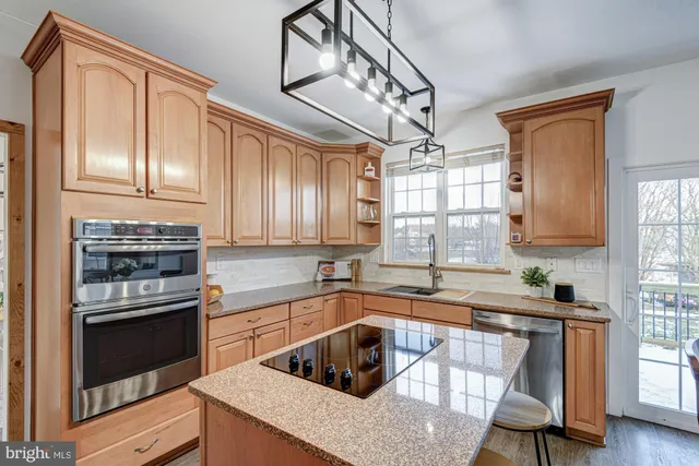 a living room with couches a fireplace and wooden floor