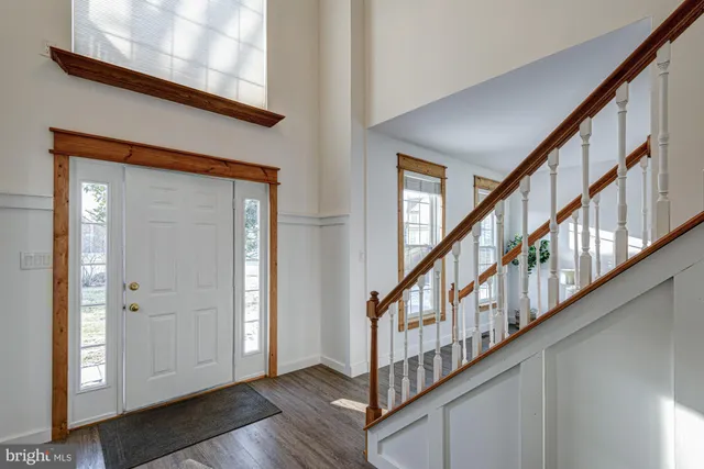 a dining room with wooden floor a chandelier a wooden table and chairs