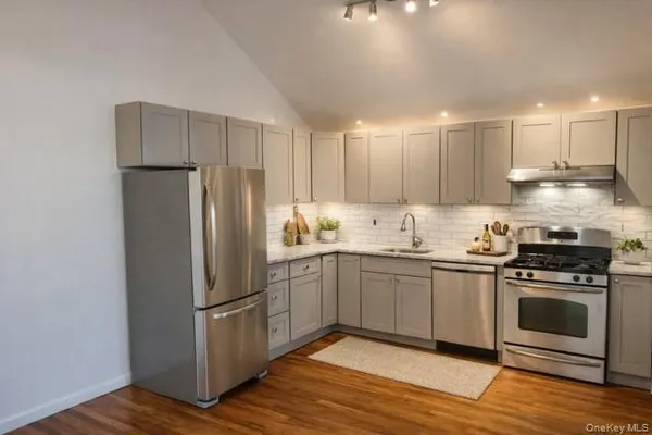 a kitchen with granite countertop a refrigerator and a stove top oven