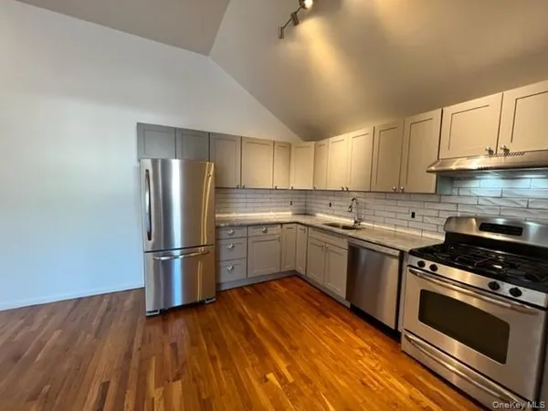 a kitchen with a refrigerator stove and wooden cabinets