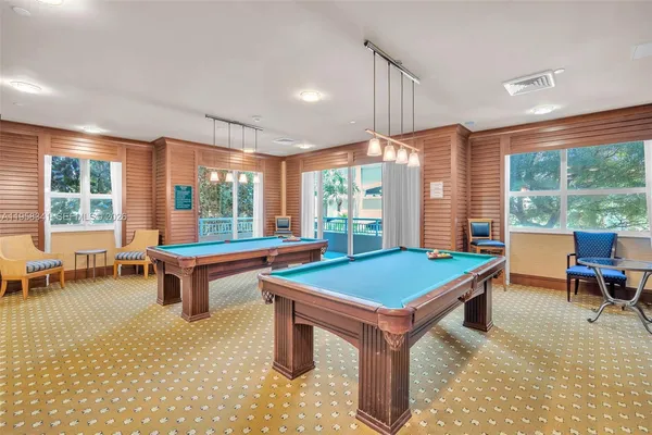a room with pool table and windows