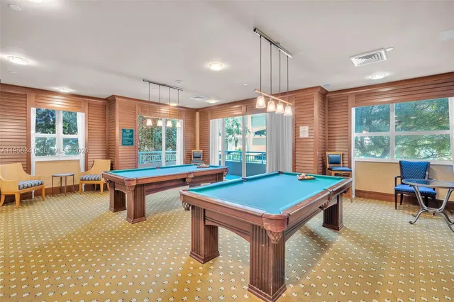 a room with pool table and windows