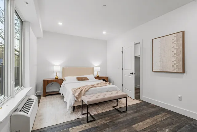 a bedroom with a bed and wooden floor