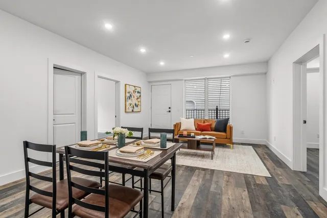 a living room with furniture a rug and a table